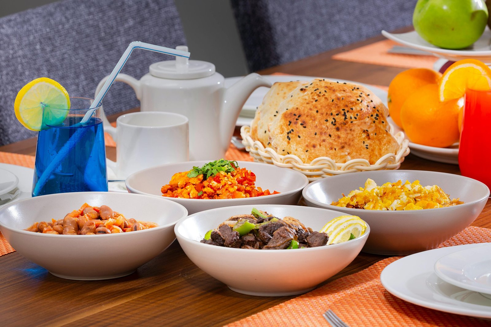 Colorful breakfast spread with fresh dishes and drinks on a modern table setup.